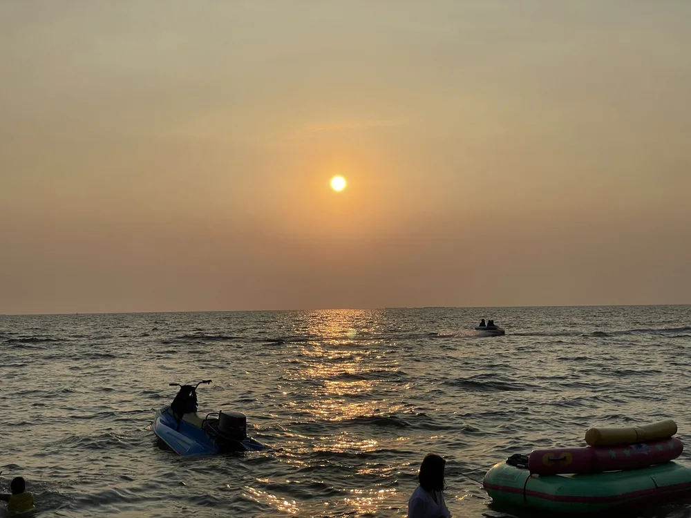 Bang Saen Beach at sunset on the Gulf of Thailand. Destination context photograph.