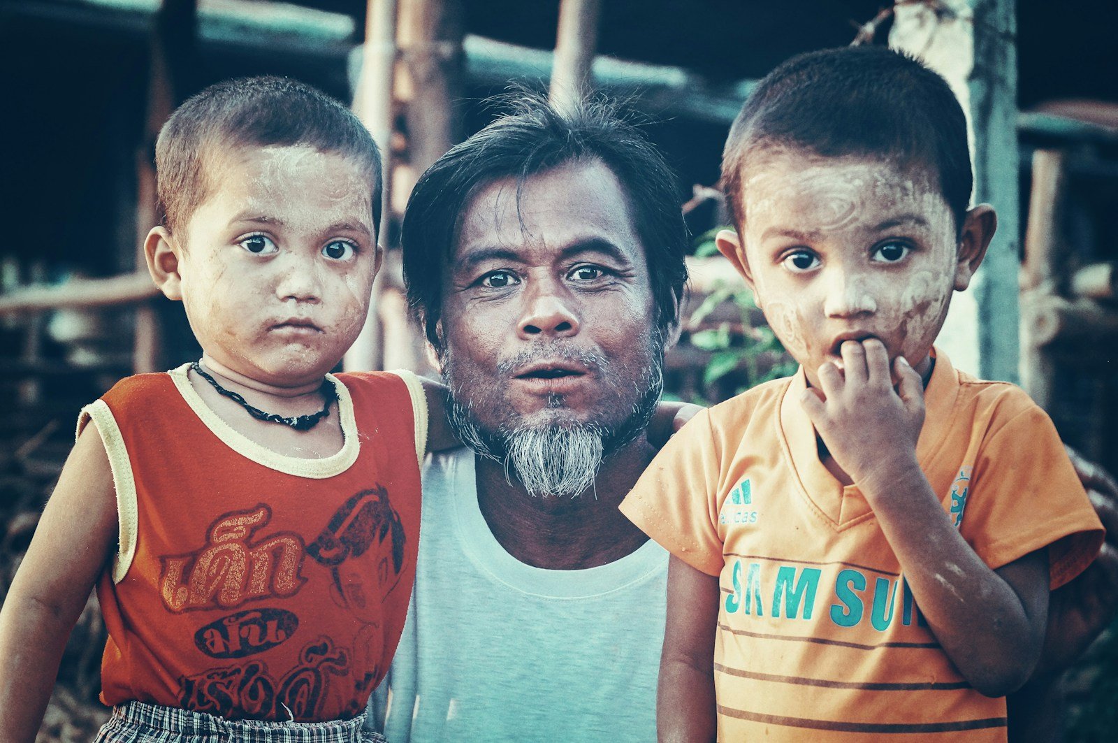 man standing between two boys