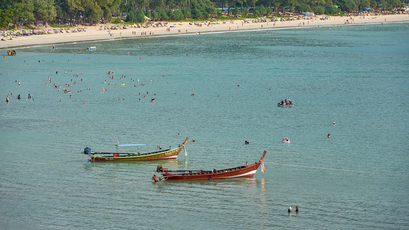 Longtail boats on turquoise water at Kata Beach, Phuket.